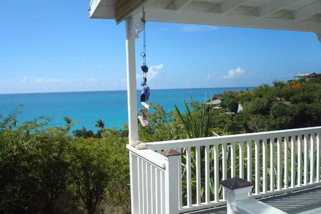 a view of the ocean from the porch of a house at Breeze Cottage in Five Islands Village
