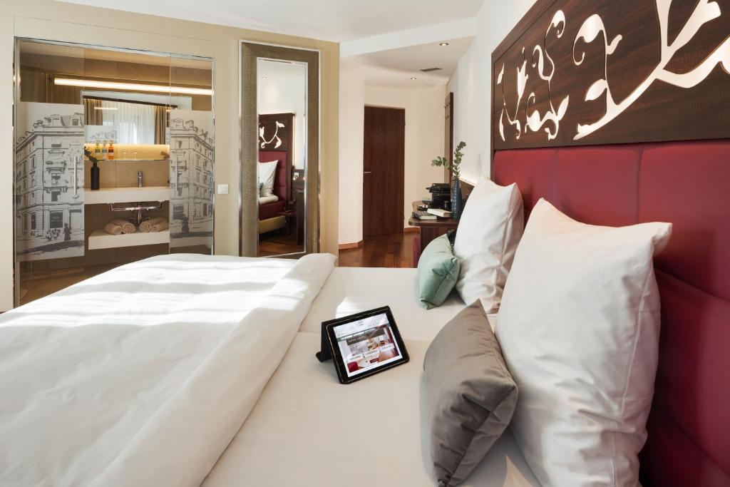 a bedroom with a large white bed with a red headboard at Hotel Scheuble in Zürich
