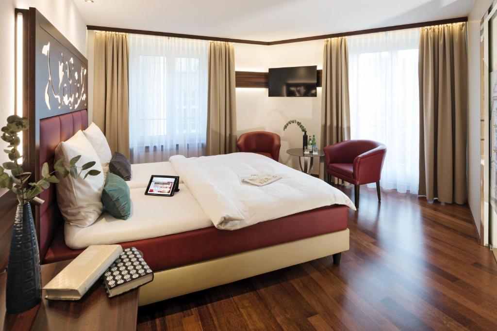 a hotel room with a large bed and a table at Hotel Scheuble in Zürich