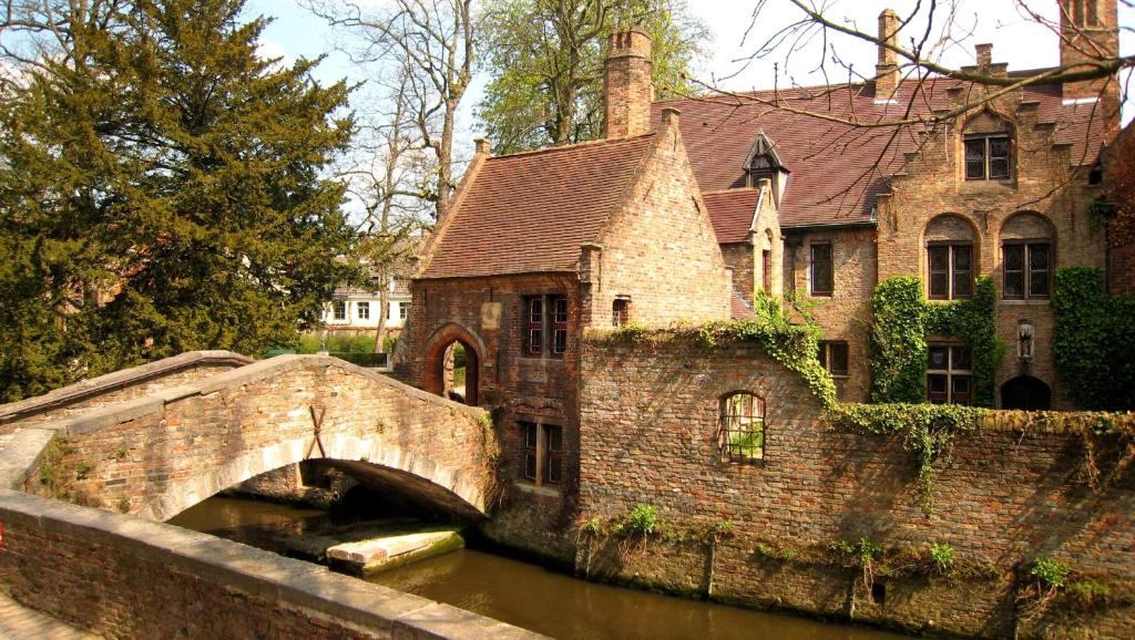 een brug over een rivier voor een gebouw bij Guest House Nuit Blanche in Brugge