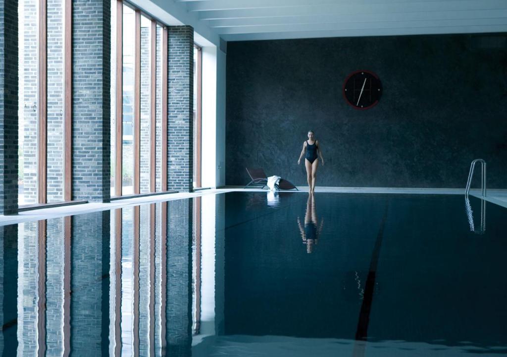 a woman standing in a swimming pool with a dog at Charlottehaven in Copenhagen