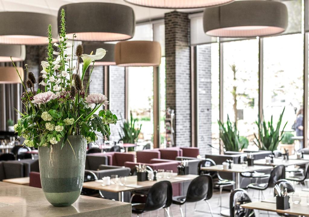 a vase of flowers on a table in a restaurant at Charlottehaven in Copenhagen