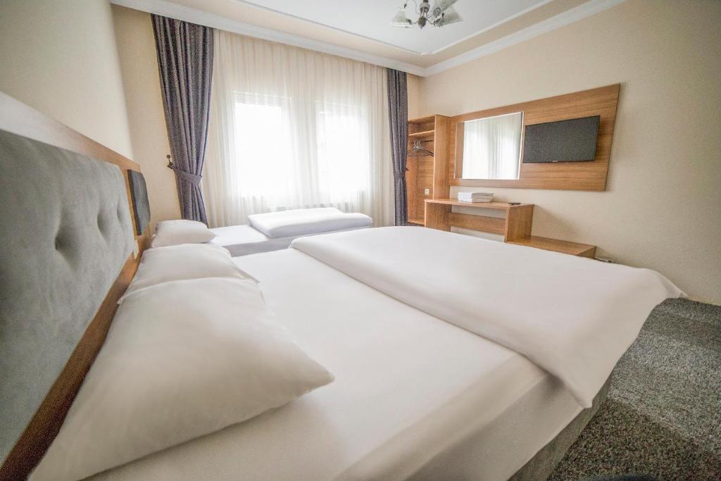 Cette chambre comprend 2 lits et une fenêtre. dans l'établissement Inceli Hotel, à Uzungöl