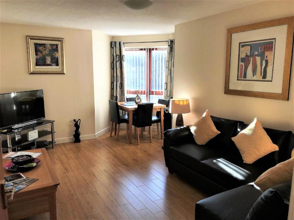 a living room with a couch and a table at Castle Gait, Paisley in Paisley