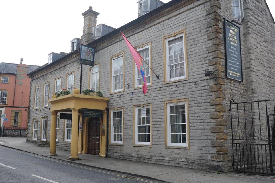 a brick building on a street with a flag at Langport Arms Hotel in Langport