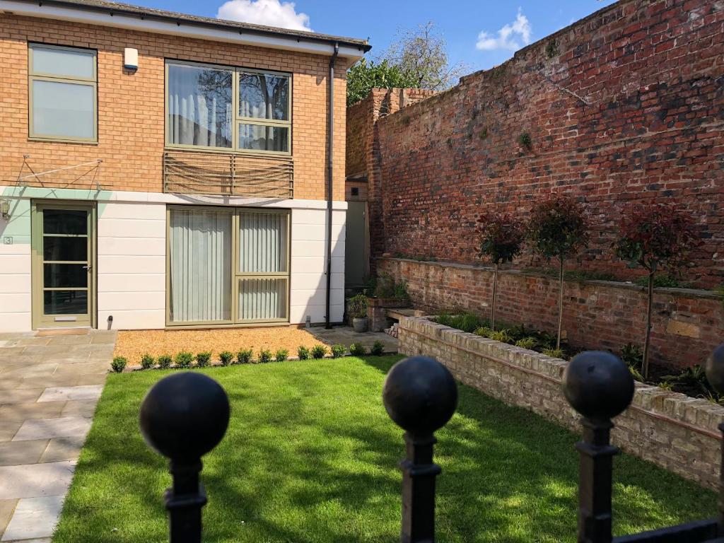 a garden in front of a brick building at Jorvik Lodge in York