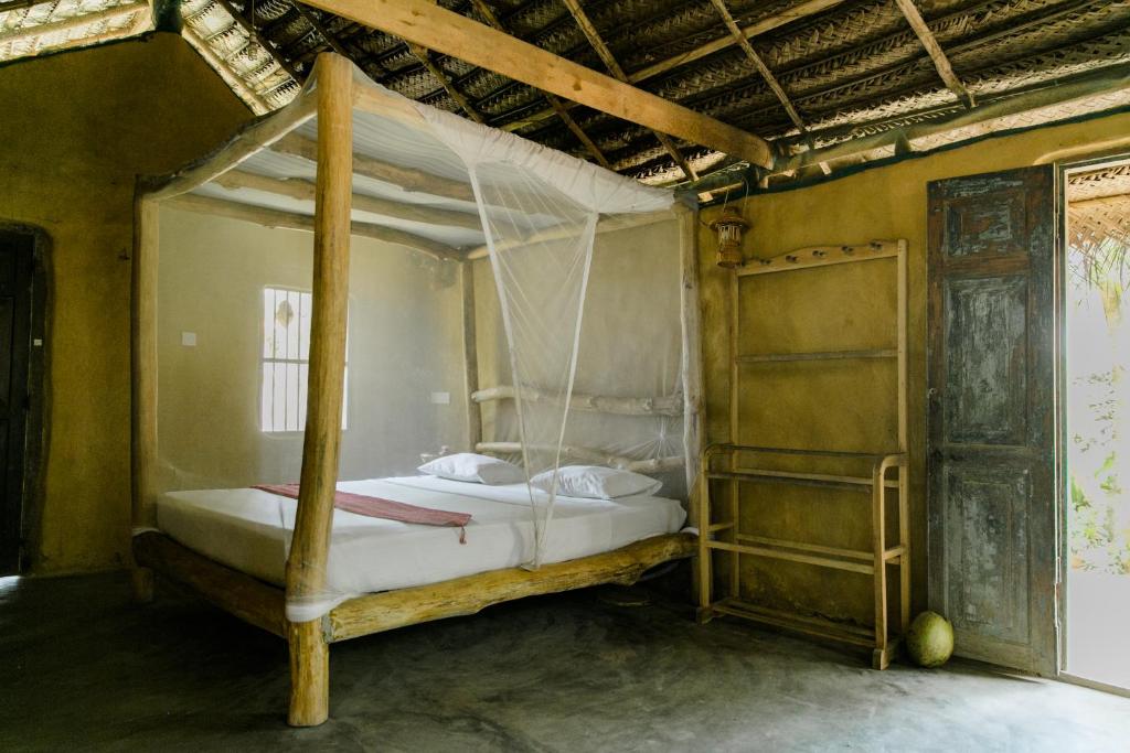 a bedroom with a bed with a hanging bed frame at Nuga Eden Tangalle in Tangalle