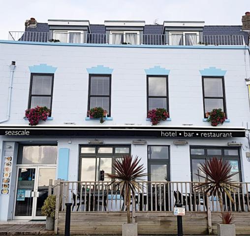 a white building with windows and plants in front of it at Seascale Hotel & Restaurant in Gorey