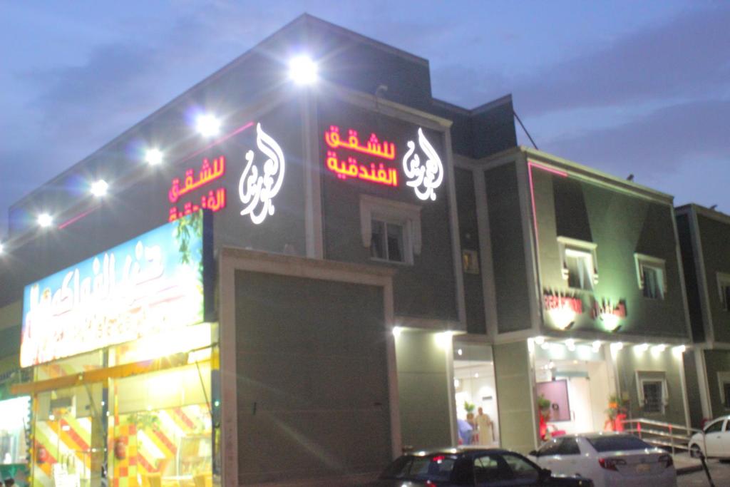 a building with neon signs on the side of it at Al Amoria Apartments in Riyadh