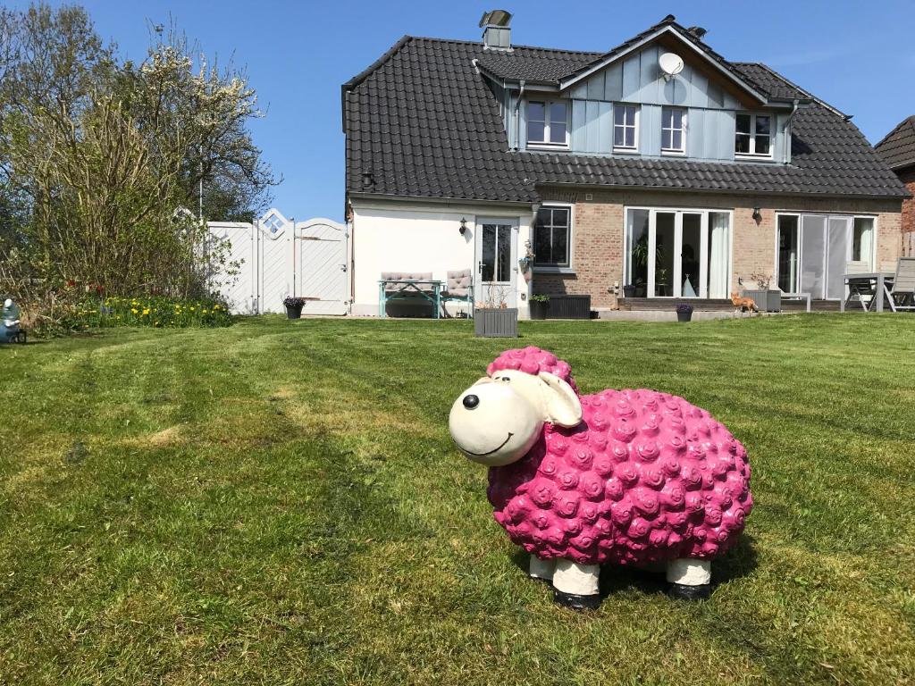 uma ovelha de peluche rosa no quintal de uma casa em Ferienwohnung Sonnentraum em Bannesdorf