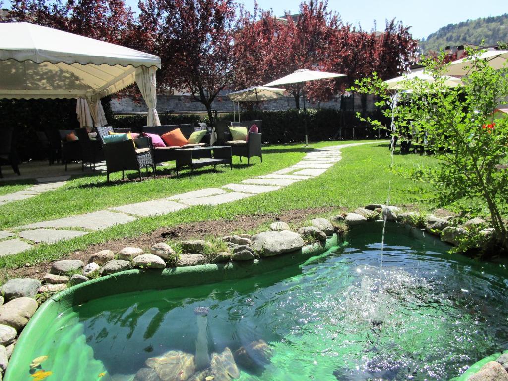 ドモドッソラにあるPalazzo Pellandaの池のある庭のスイミングプール