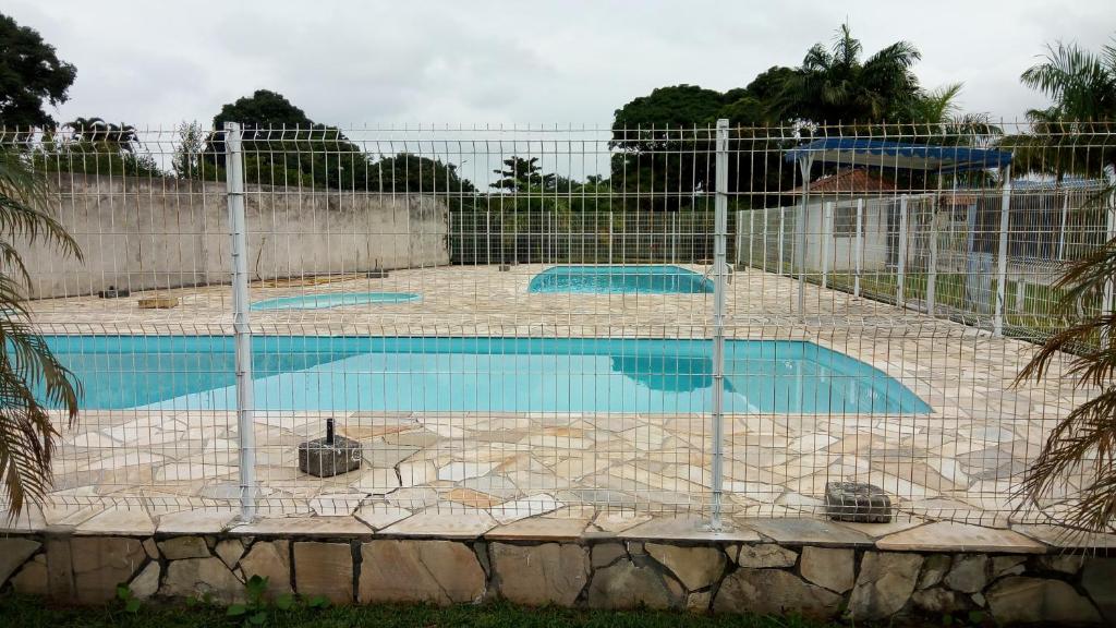 a swimming pool with a fence around it at Kitinete Em Matinhos Com Piscina in Matinhos