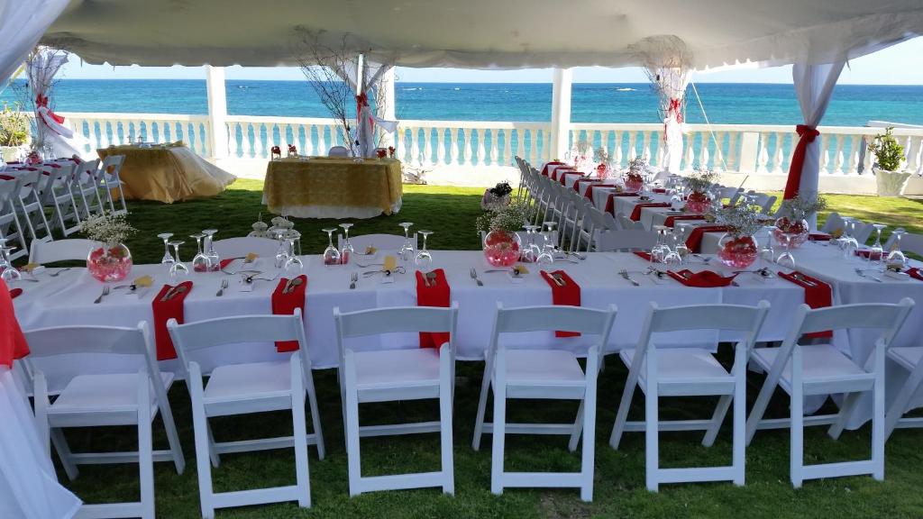 a table set up for a wedding with the ocean in the background at Whispering Bamboo Cove Resort in Belfast
