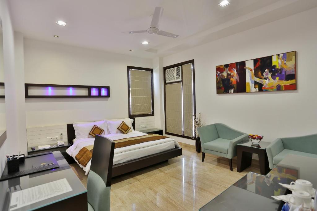 Habitación con cama, sofá y silla en Hotel D'PRESIDENTE, en Nueva Delhi