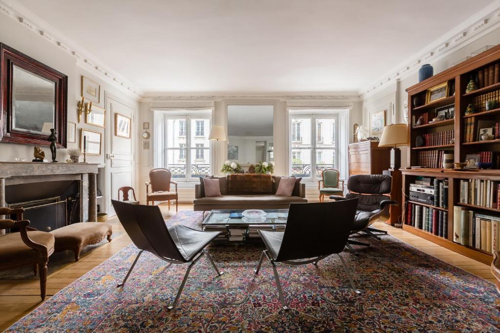 un salon avec un canapé, une table et des chaises dans l'établissement Veeve - Latin Quarter Retreat, à Paris