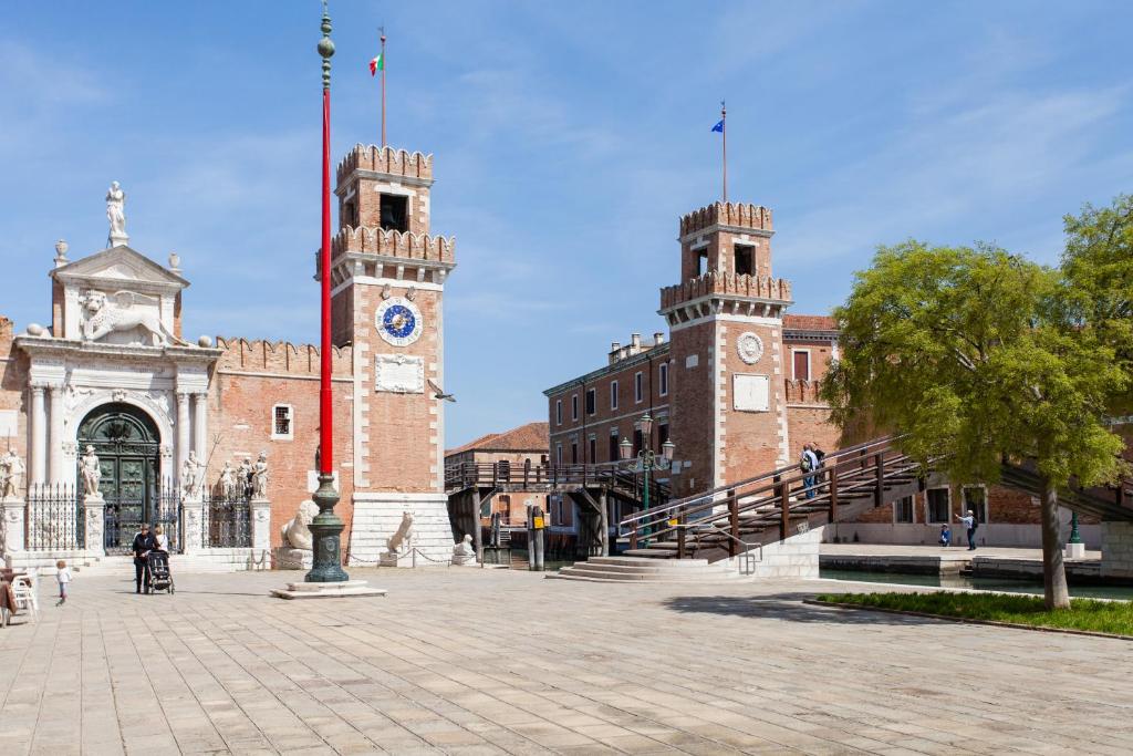 ヴェネツィアにあるPrince Apartmentsの時計塔が前に建つ大きなレンガ造りの建物