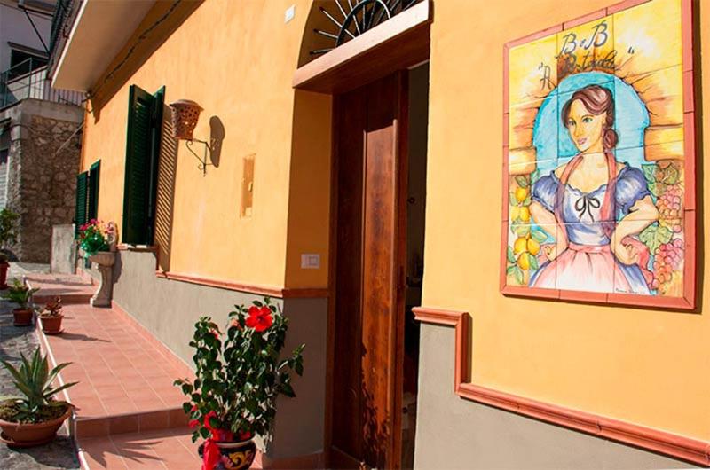 Un dipinto di una donna sul lato di un edificio di A Pastaiola a Cetara