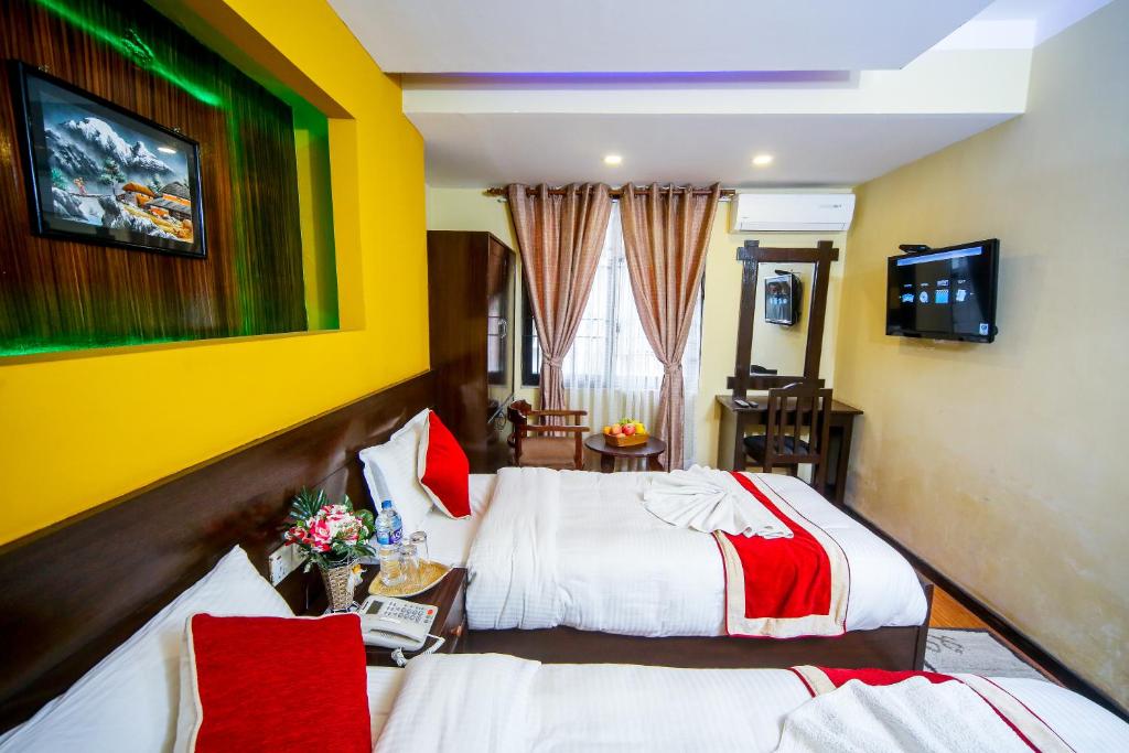 a hotel room with two beds and a tv at Thamel Home in Kathmandu
