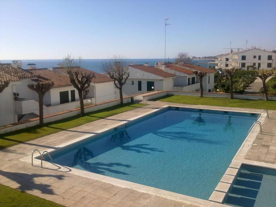 Una gran piscina en un patio con casas. en Sitges - Apartamento, en Sitges