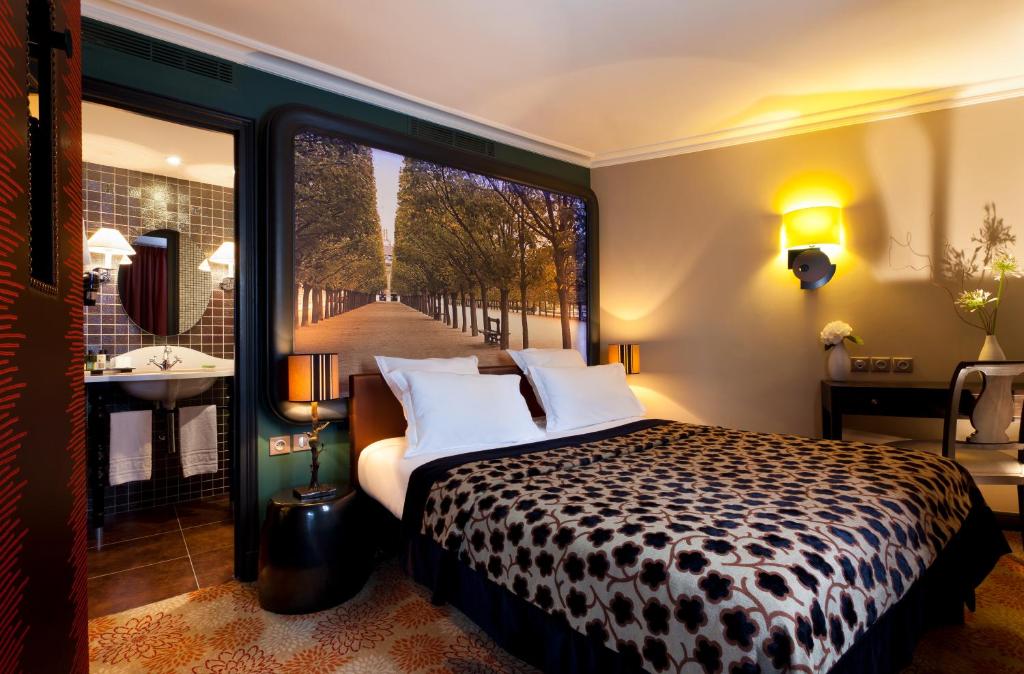 Schlafzimmer mit einem Bett und Blick auf ein Bad in der Unterkunft Hotel Fontaines du Luxembourg in Paris
