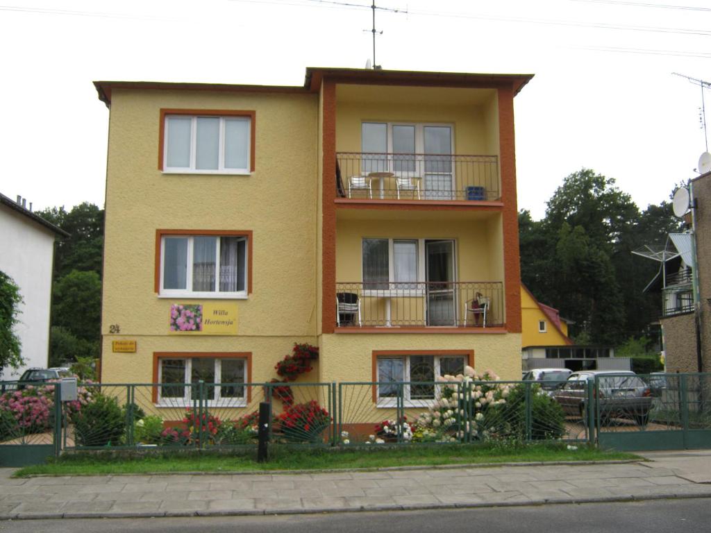 ミエンジズドロイェにあるWilla Hortensjaの黄色の建物(窓、バルコニー付)