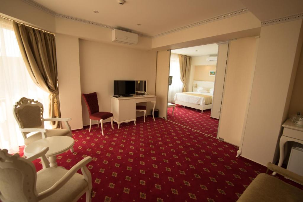 a hotel room with a bed and a tv at MSR Port Hotel in Mangalia