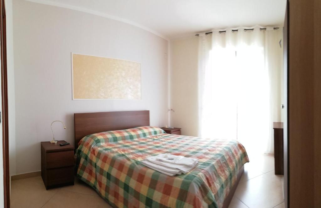 una camera da letto con un letto con una coperta scozzese e una finestra di Incontro Montoro Guest House & Restaurant a Montoro Inferiore
