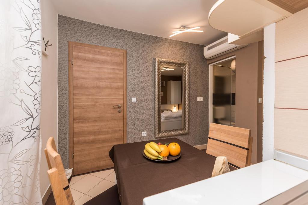 a dining room with a table with bananas and oranges on it at Apartments Donat in Zadar