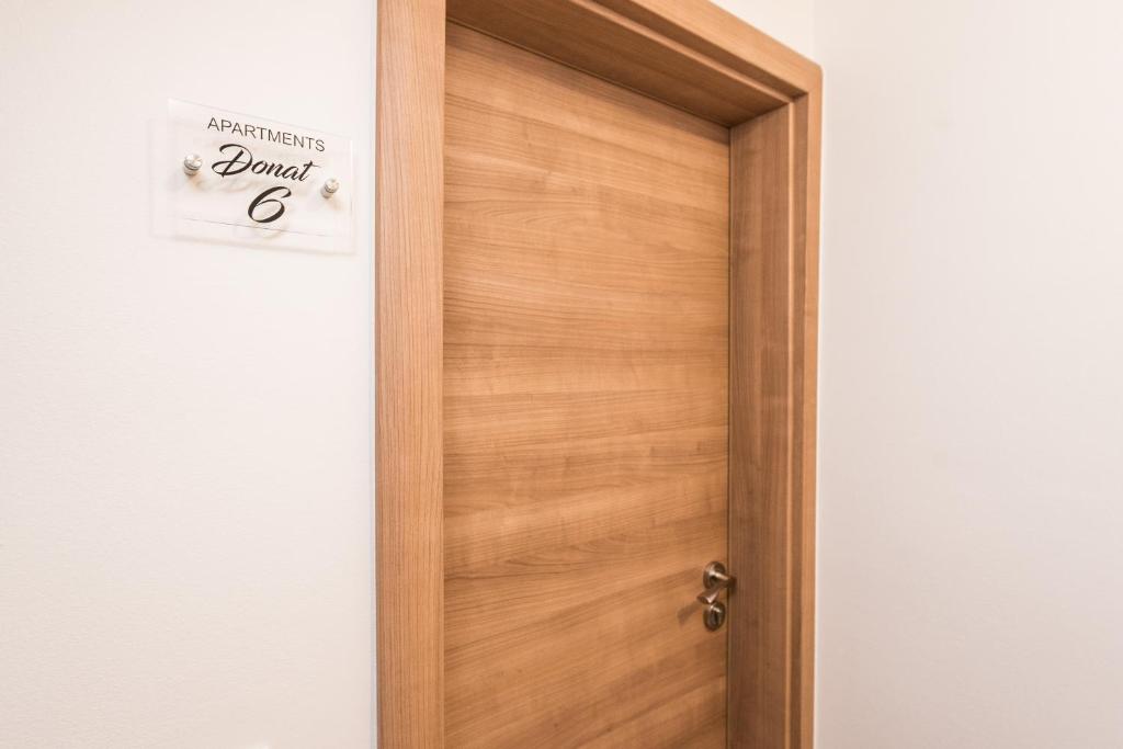 a wooden door with a sign that reads danger at Apartments Donat in Zadar