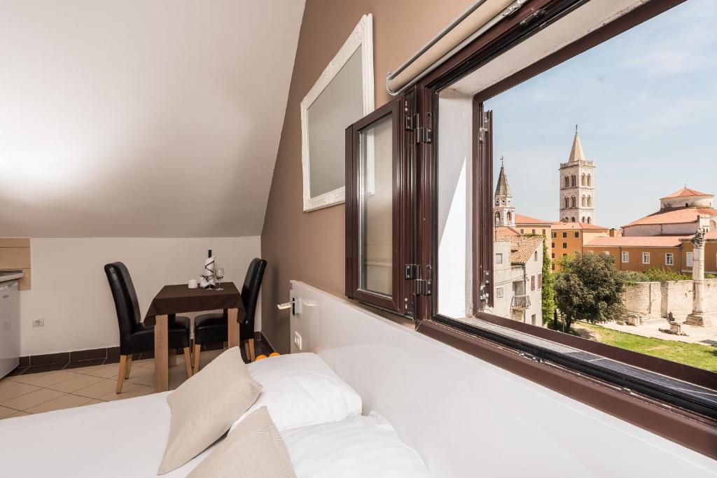 a bedroom with a bed and a large window at Apartments Donat in Zadar