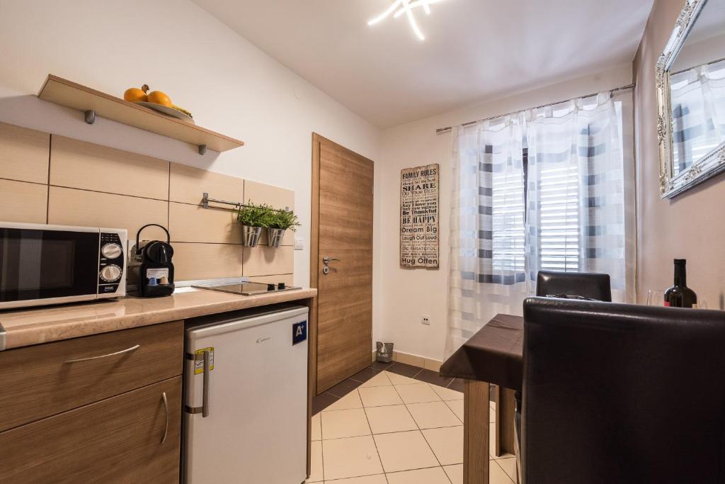 a small kitchen with a table and a microwave at Apartments Donat in Zadar