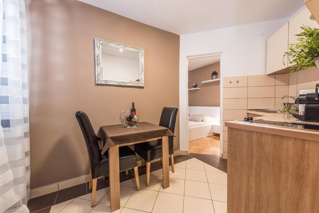 a kitchen and dining room with a table and chairs at Apartments Donat in Zadar