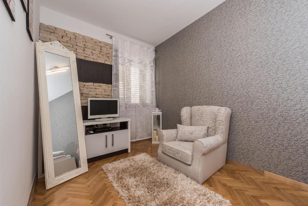 a living room with a chair and a television at Apartments Donat in Zadar