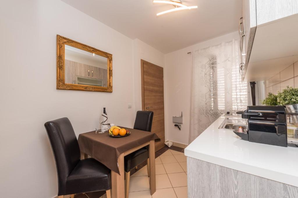 a kitchen with a small table and chairs in a room at Apartments Donat in Zadar