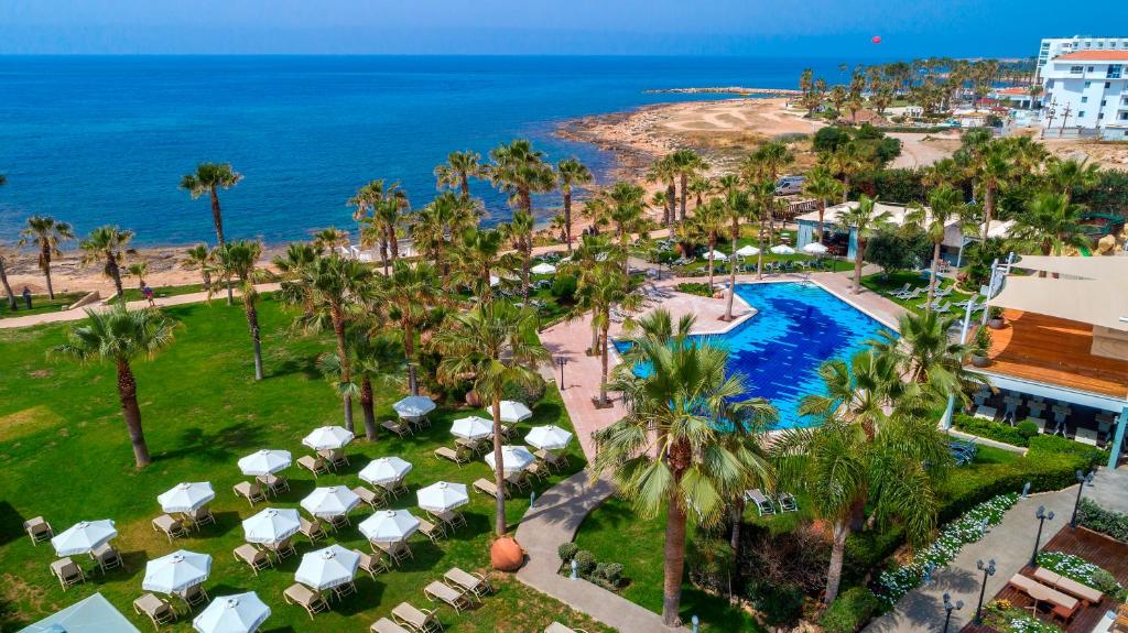 een luchtzicht op een resort met een zwembad en de oceaan bij Aquamare Beach Hotel & Spa in Paphos City