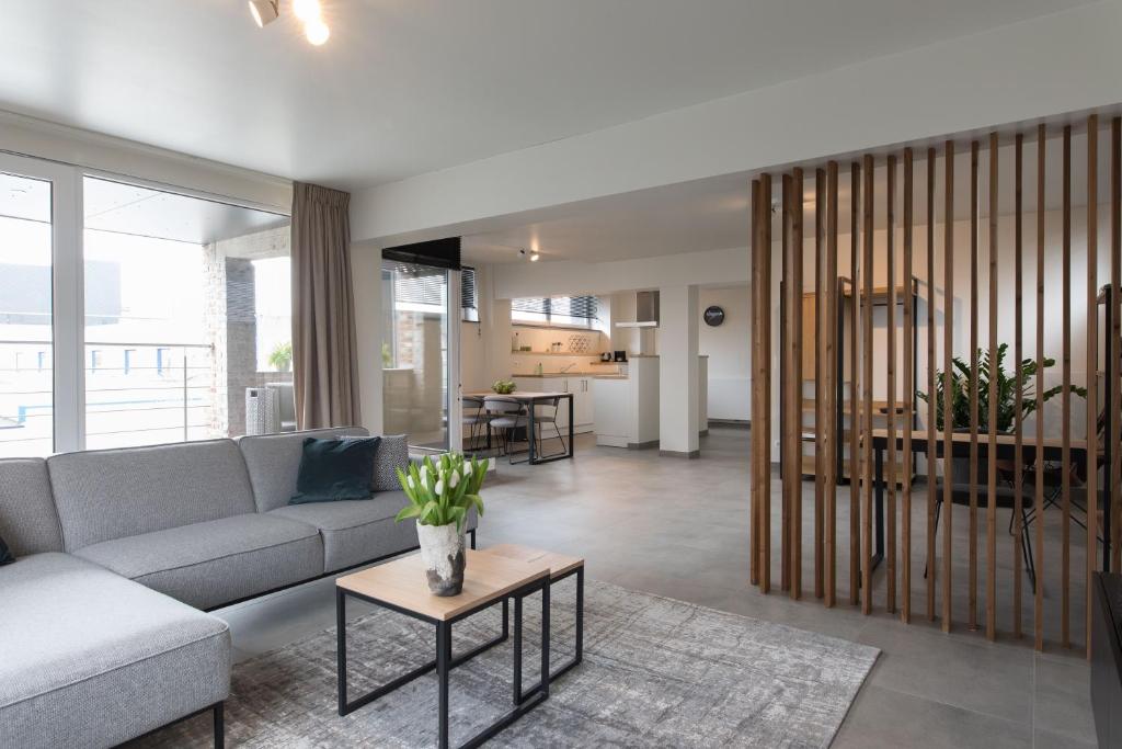 a living room with a couch and a table at Raveel Lofts in Deinze