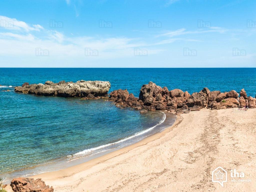 una spiaggia sabbiosa con rocce e oceano di Las Dos Islas a Castelsardo