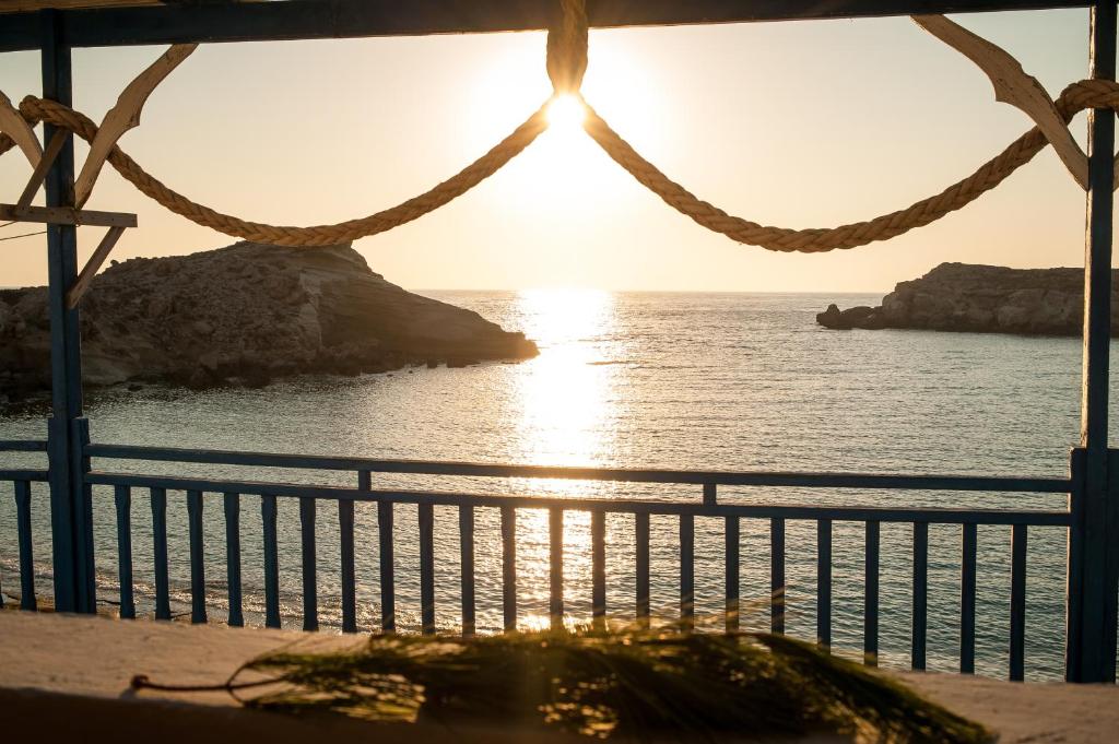 a view of the ocean from a balcony at sunset at Zorbas Studios in Lefkos Karpathou