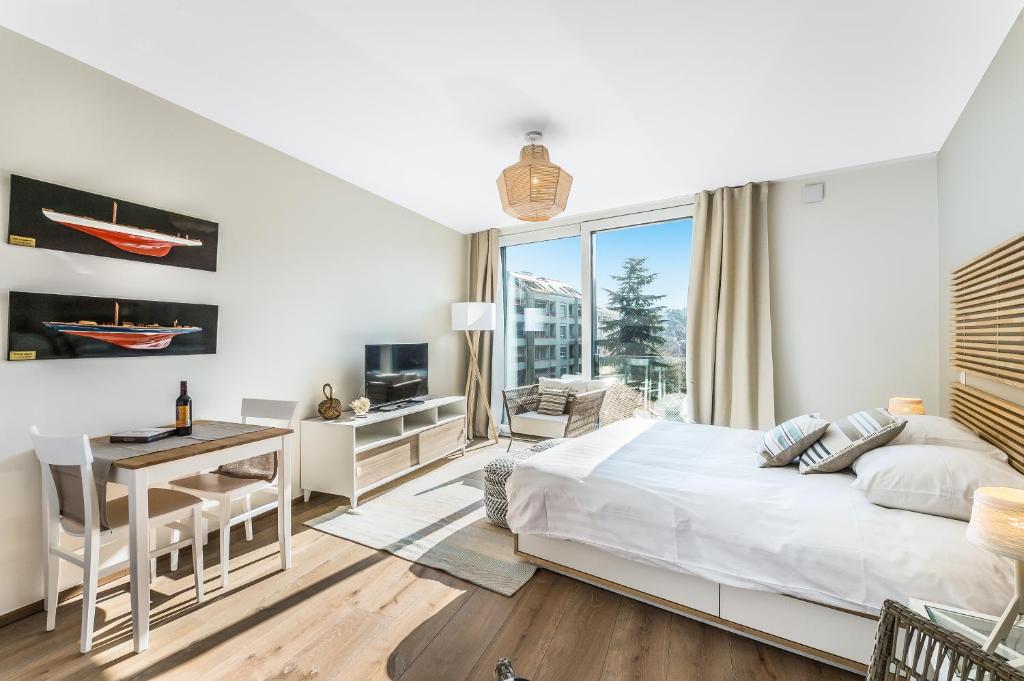 Schlafzimmer mit einem Bett, einem Schreibtisch und einem Fenster in der Unterkunft N20 Residence by Homenhancement in Genf