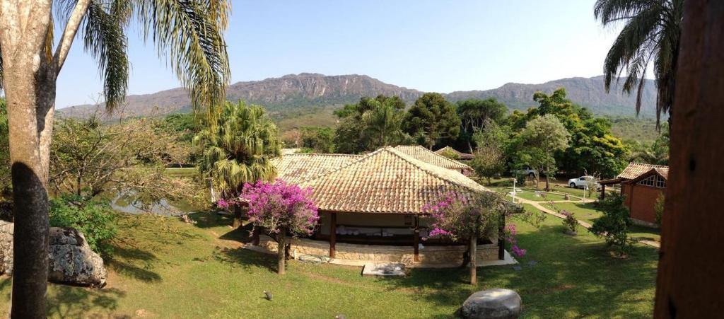 uma casa num campo com montanhas ao fundo em Calcada Sao Jose em Tiradentes