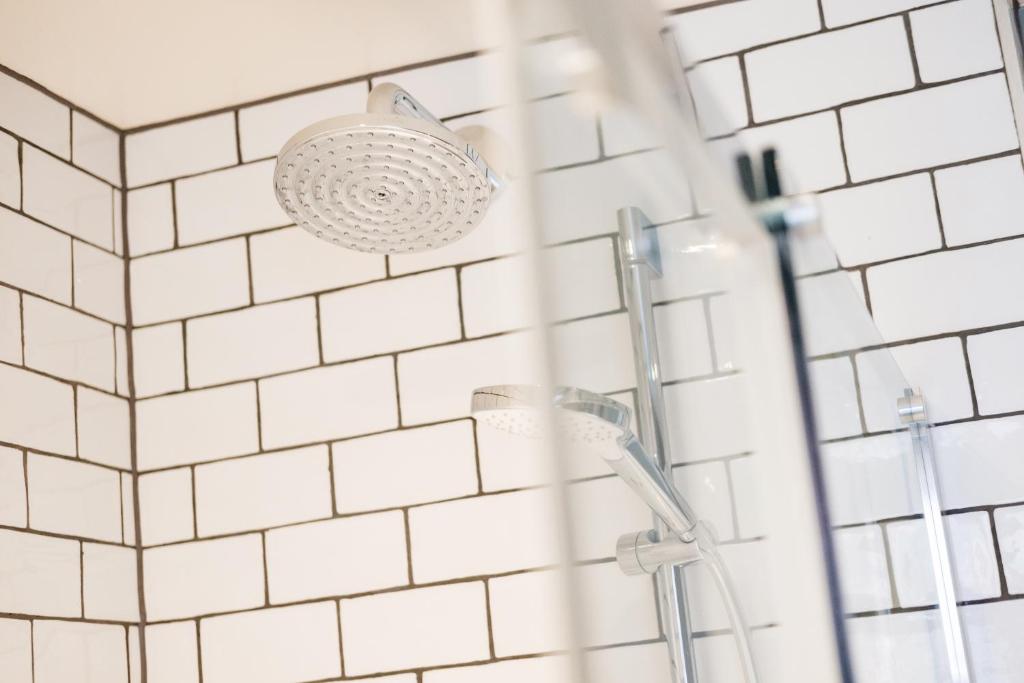 a bathroom with white tiled walls and a shower at Wykeham Arms in Winchester