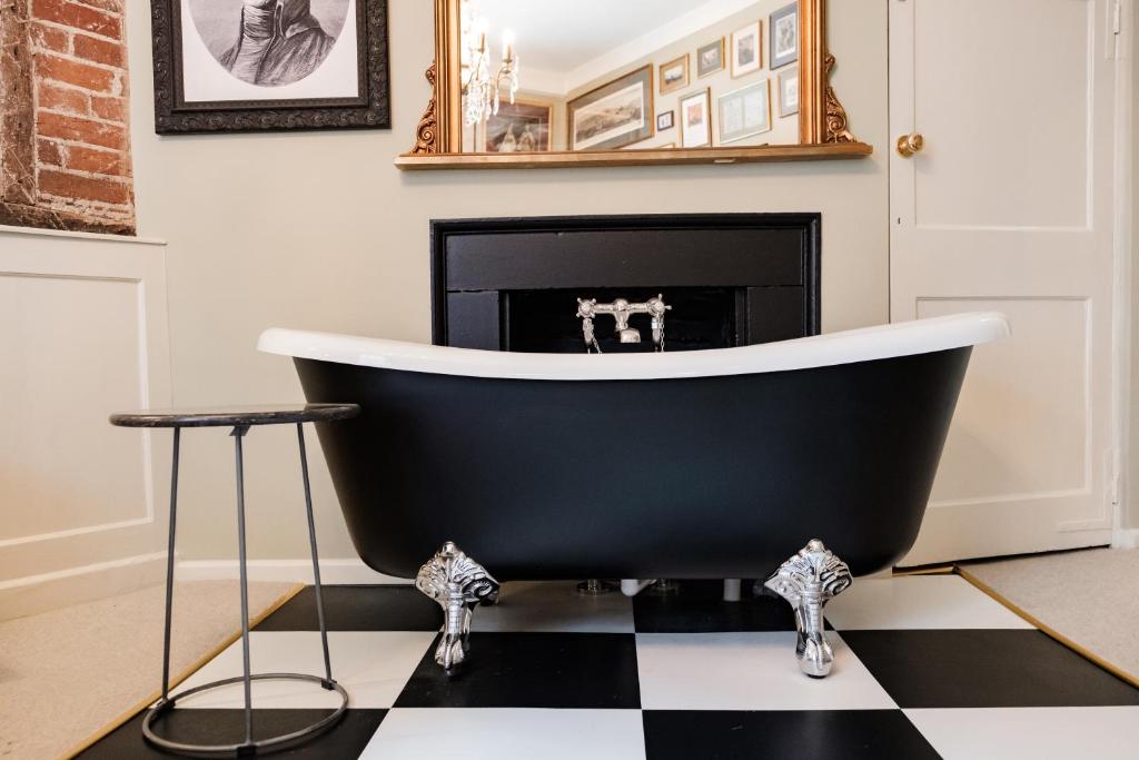 a black bathtub in a living room with a fireplace at Wykeham Arms in Winchester