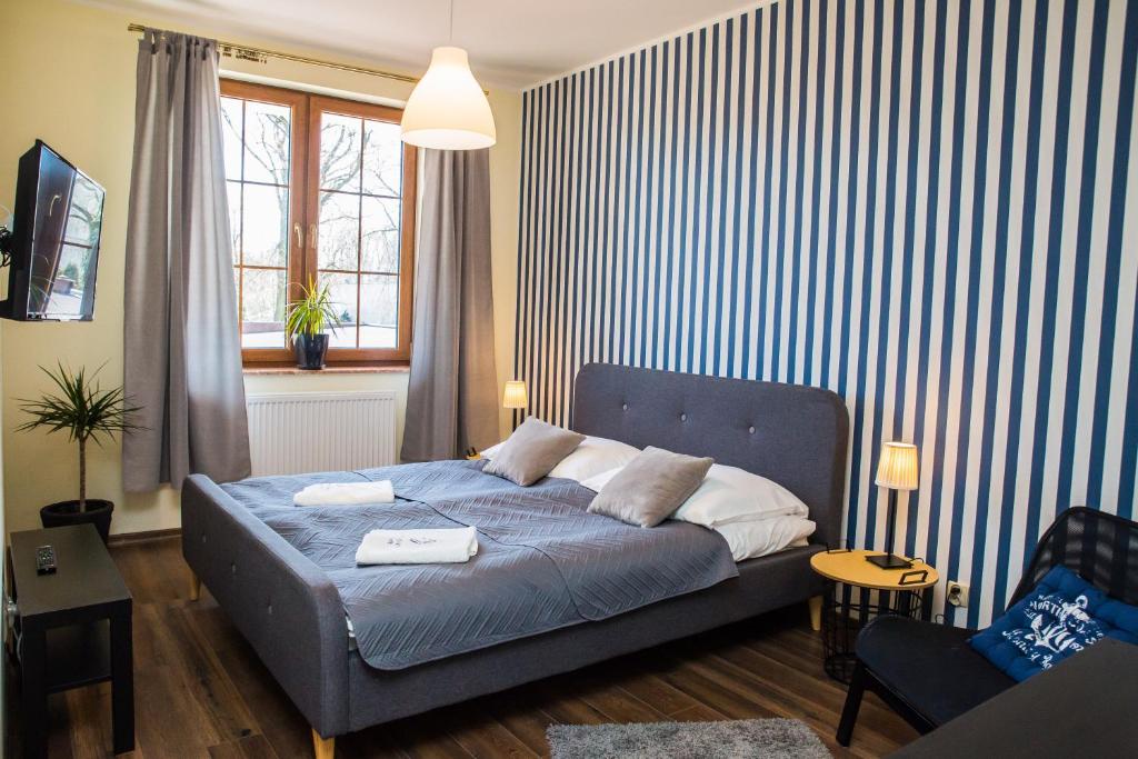 プツクにあるApartament Żaglowy 1のベッドルーム1室(青と白のストライプの壁の青いベッド1台付)