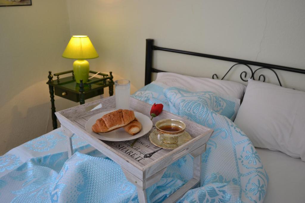 a tray with a plate of bread on a bed at Limenaria Stone House in Limenaria
