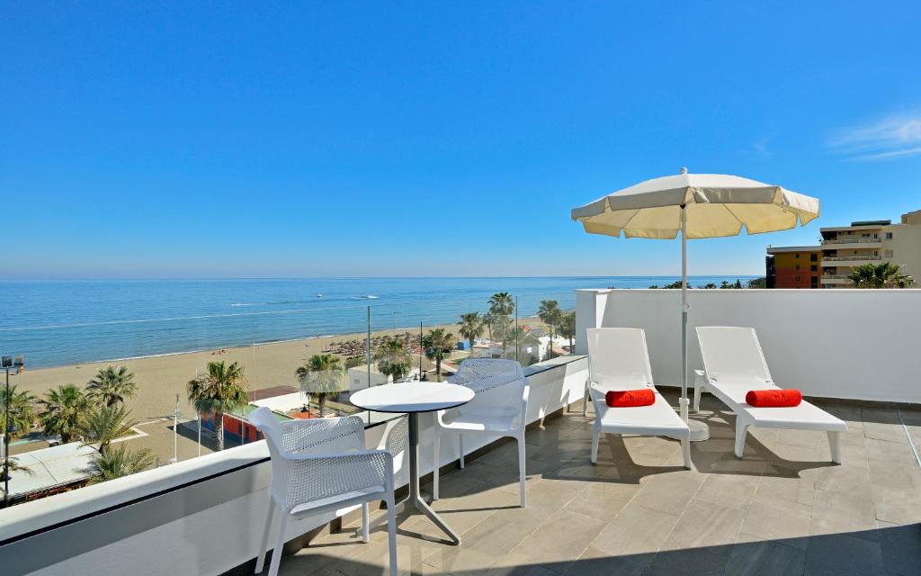 a balcony with a table and chairs and the beach at Sol Torremolinos - Don Marco Adults Recommended in Torremolinos
