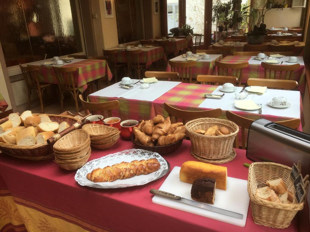 a table with bread and baskets of food on it at Hôtel aux Bruyères in Orbey