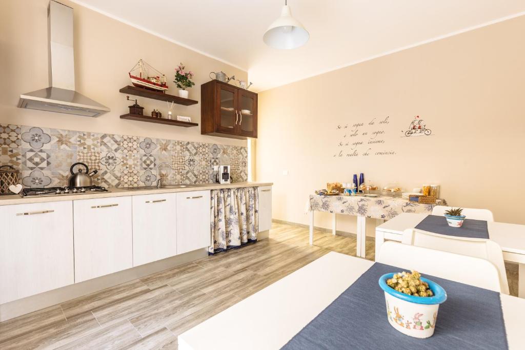 a kitchen with white cabinets and a table at B&B Medusa in Santa Flavia