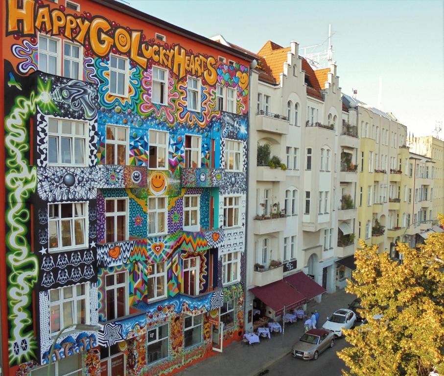 een gebouw met een kleurrijke muurschildering aan de zijkant bij Happy Go Lucky Hotel + Hostel in Berlijn