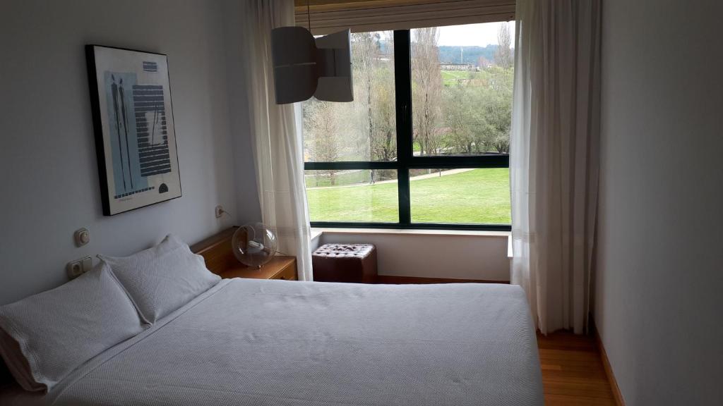 een slaapkamer met een bed en een groot raam bij PR Blanco in Santiago de Compostela