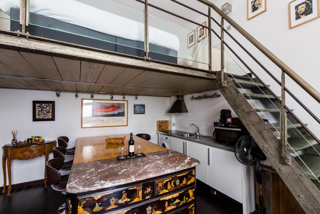 une cuisine avec une table en bois et une mezzanine dans l'établissement Veeve - Heart of Saint Germain, à Paris